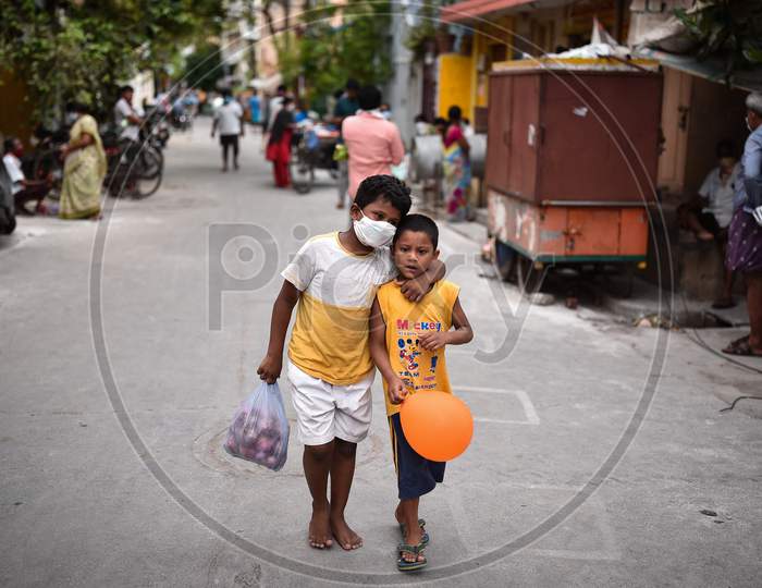 A Boy Carries Onions As He Walks With His Friend Along A Street During The Nationwide Lockdown Imposed In The Wake Of Coronavirus, In Vijayawada.