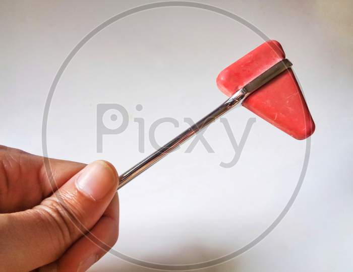 A man holding a knee hammer isolated on white background, medical equipment