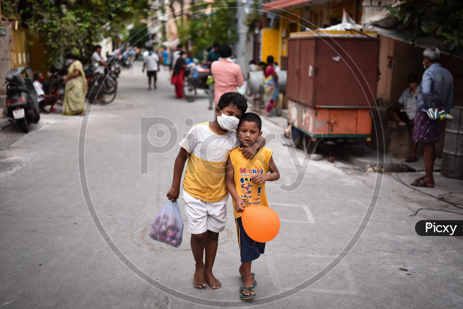 A Boy Carries Onions As He Walks With His Friend Along A Street During The Nationwide Lockdown Imposed In The Wake Of Coronavirus, In Vijayawada.