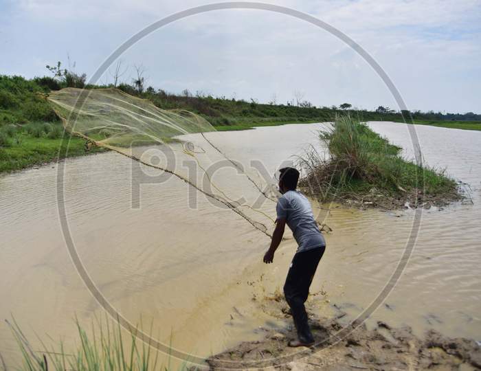 A Fisherman Casts His Fishing Net At A Lake During Nationwide Lockdown Amidst Coronavirus Or COVID-19 Pandemic At  Dharamtul In Morigaon District Of Assam On May 2, 2020