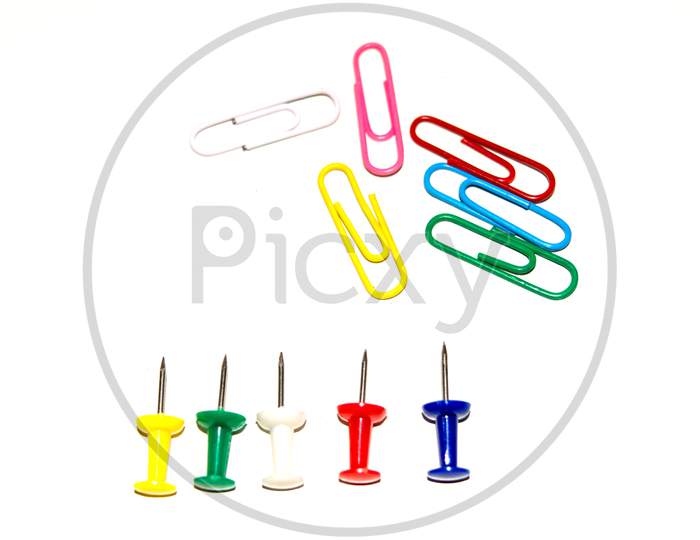 Push pins and paper clips in different colors isolated on white background.