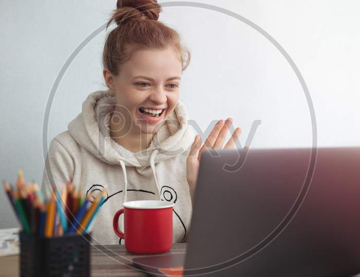 Young Caucasian woman with laptop at home making a video call, talking and smiling. Stay in touch with family concept