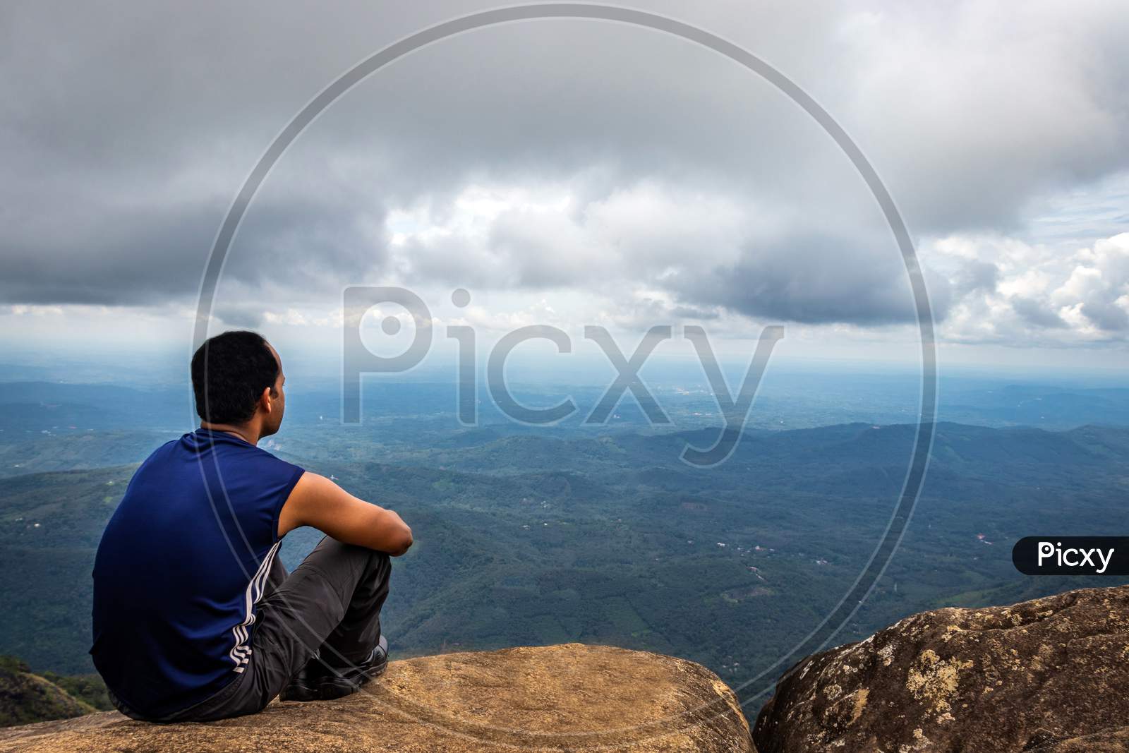 Man Isolated Sitting On The Hilltop Watching Landscape