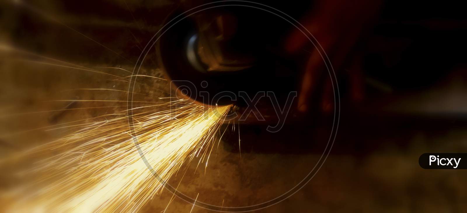 Electric Wheel Grinding On Steel Structure In Factory. Sparks From The Grinding Wheel.Selective Focus With Blurry Background.