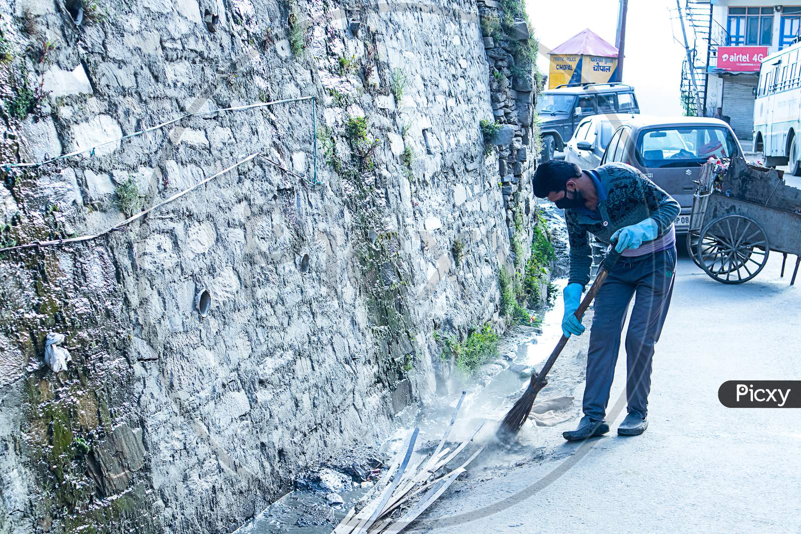 Shimla, Himachal Pradesh, India - July 20Th, 2019: Municipal Worker Sweep The Road And Drainage With Broomstick And Collects Garbage, Sanitation Worker Sweep Street