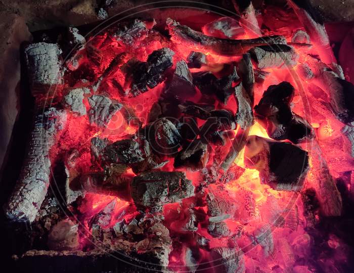 Close Up View of Glowing And Flaming Hot Charcoal. Burning Charcoal in the Background. Hot Sparking Coals Burning.