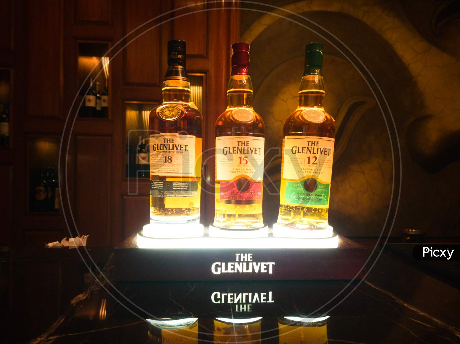 Photograph Of Glenlivet Bottles Arranged On A Beautifully Lit Stand