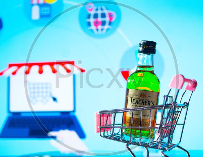 A bottle of whiskey in a trolley in front of a bright board