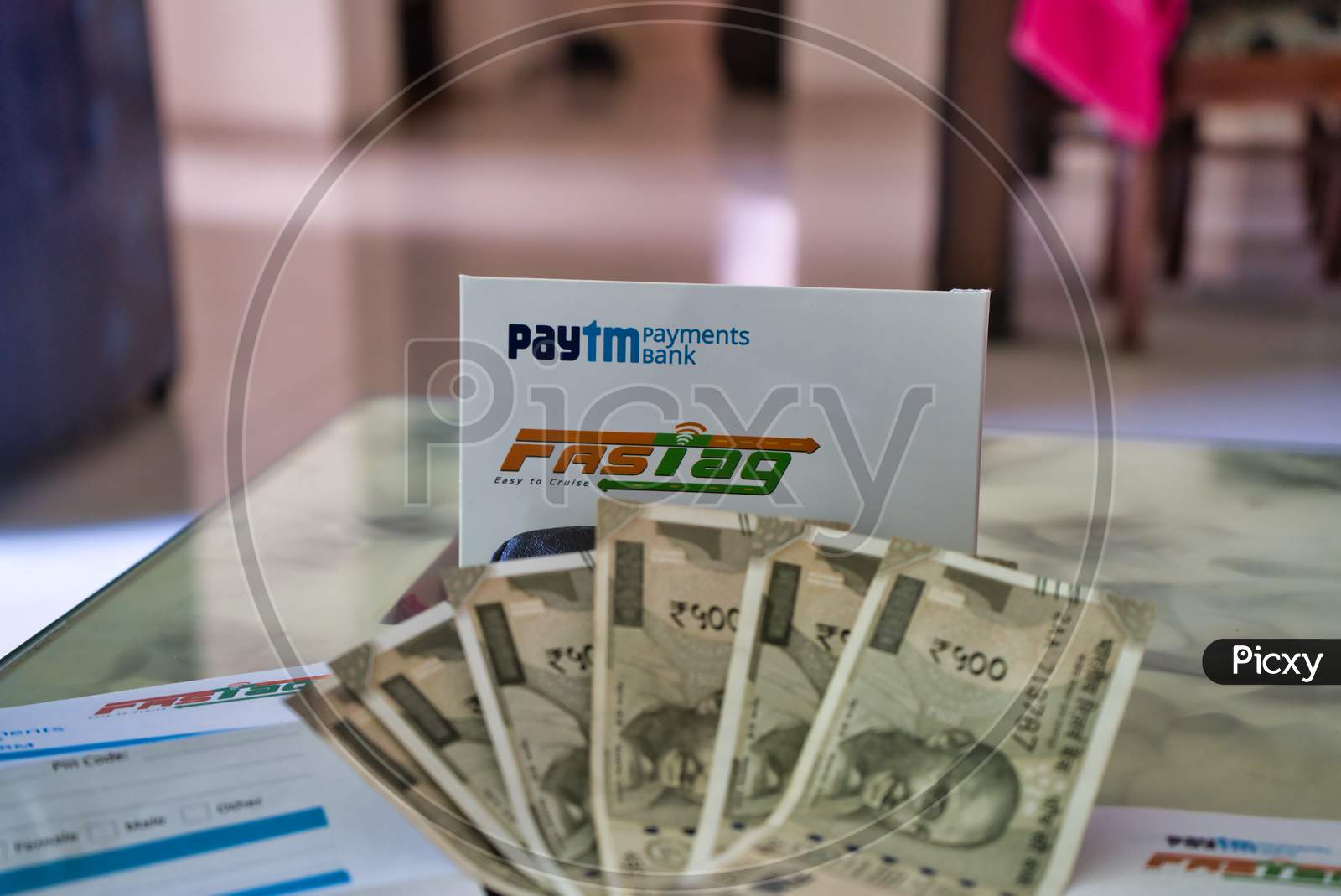 Fast Tag Provided By Paytm Payment Bank On A Beautifully Crafted Table Along With Currency Notes.