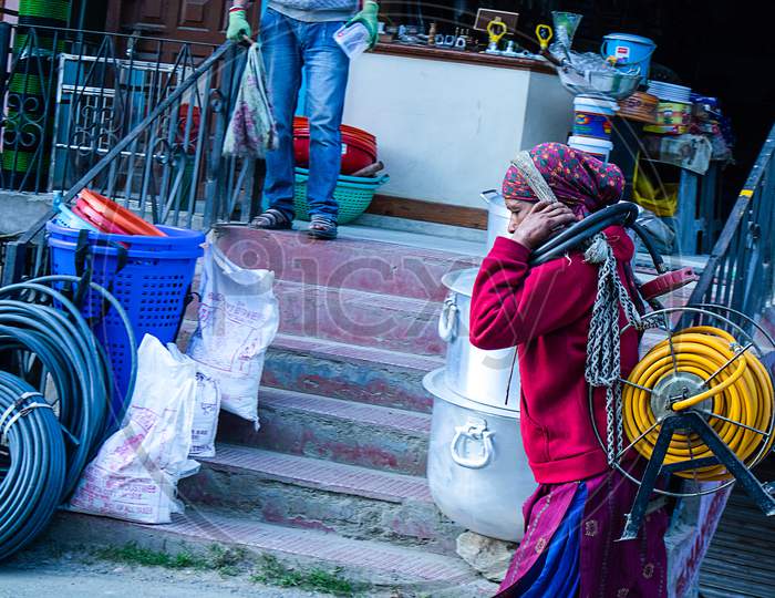 Shimla, Himachal Pradesh, India - July 20Th, 2019: Indian Women Walking On Street.Lifting Heavy Electric Cable Roll On Her Head.