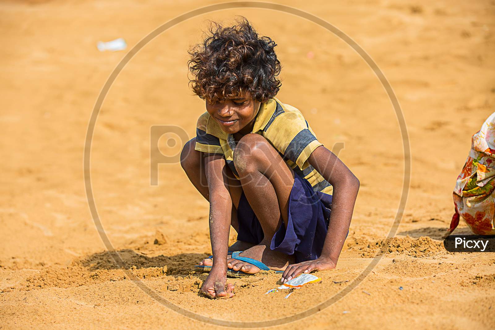 Jodhpur, Rajasthan, India - June 18Th, 2019: Poor Rural Boy Kid Playing With Sand In Hot Summer, Smiling Towards Camera, Poverty Unprivileged Indian Children.