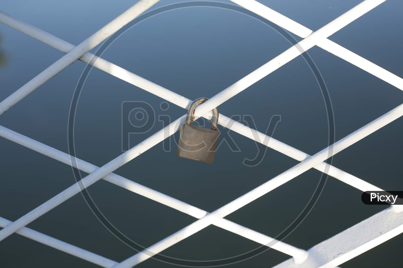 A Padlock Locked Around The Bridge Fence