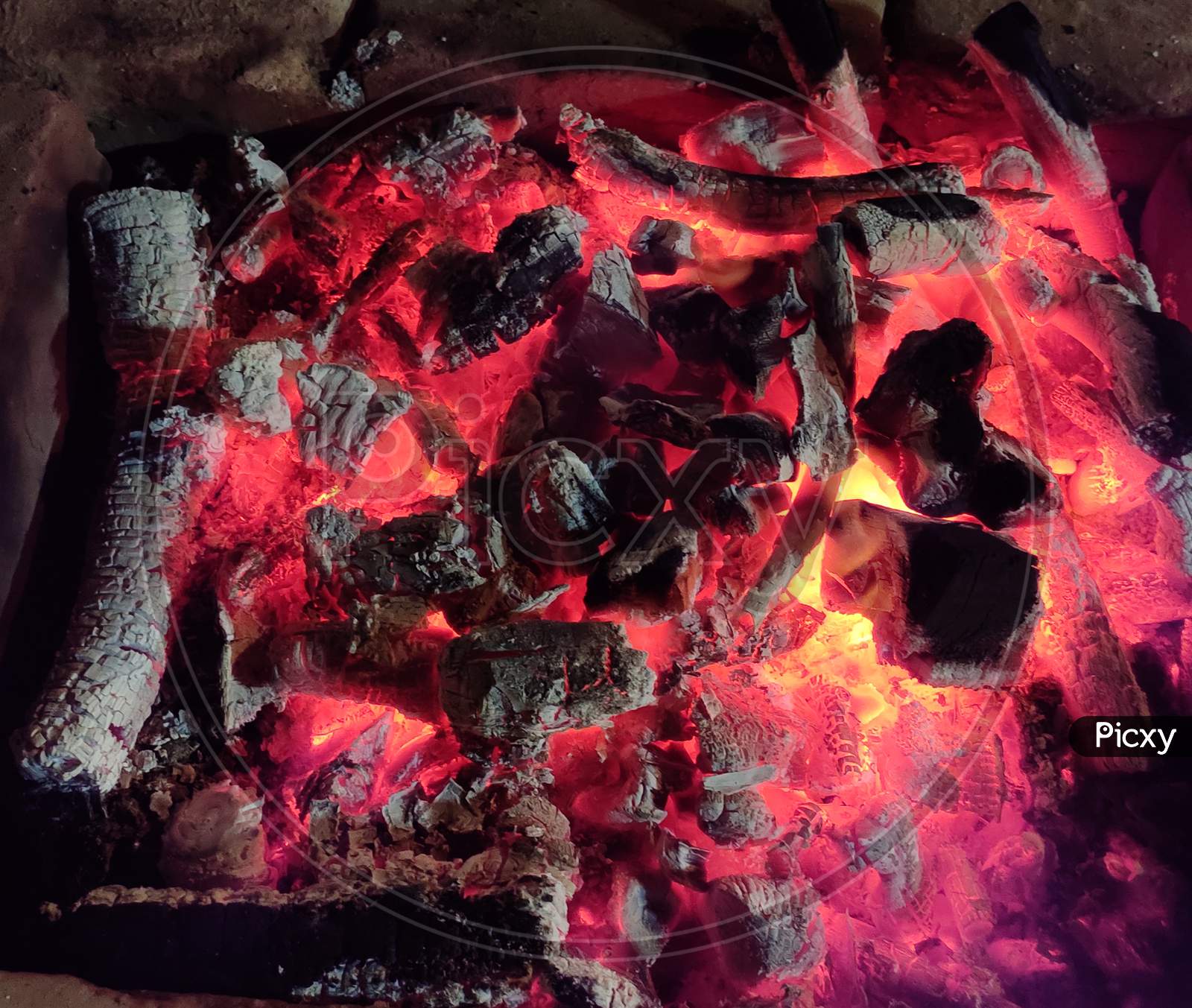 Close Up View of Glowing And Flaming Hot Charcoal. Burning Charcoal in the Background. Hot Sparking Coals Burning.