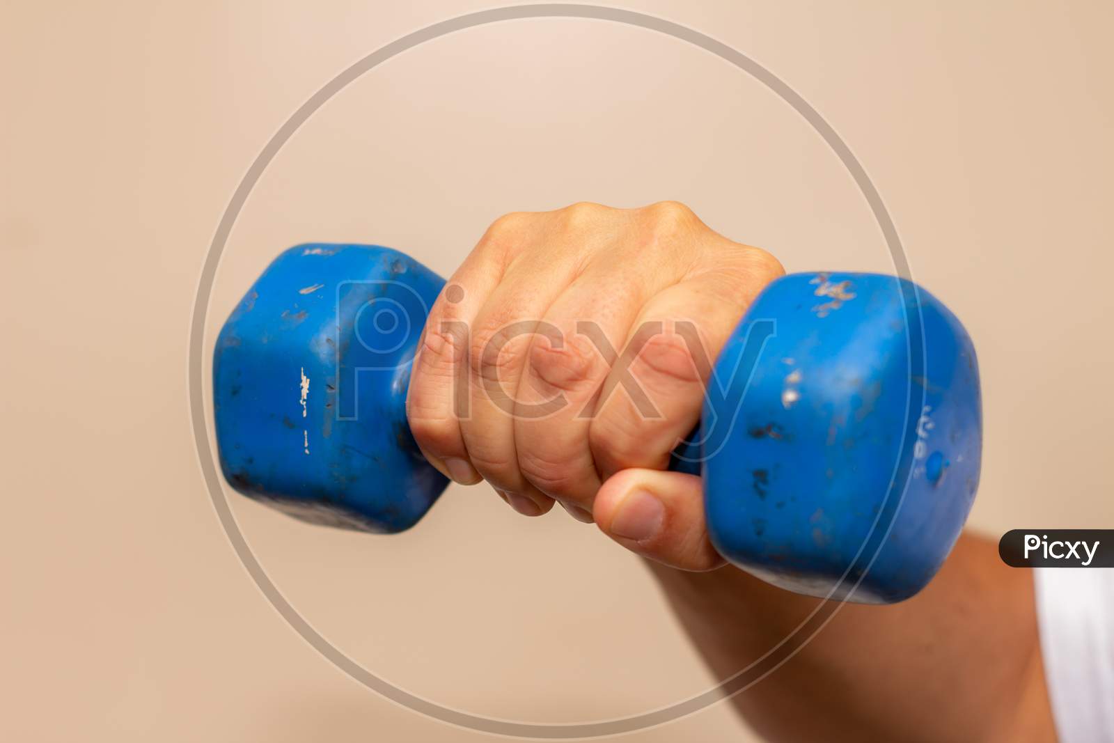Man Exercising His Arm With A Small Blue Dumbbell. Muscle Exercise