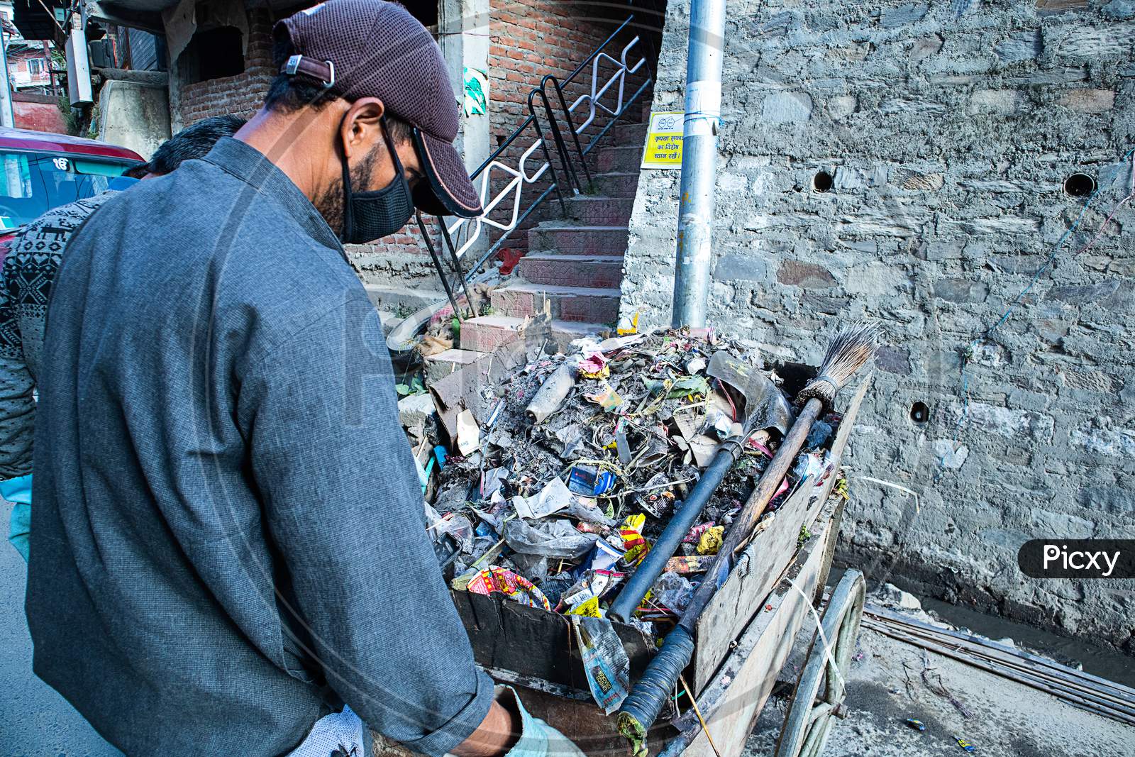 Shimla, Himachal Pradesh, India - July 20Th, 2019: Indian Asian Garbage Man Collecting Garbage In The Garbage Cart. Concept About Environmental Conservation And Ocean Pollution Problems