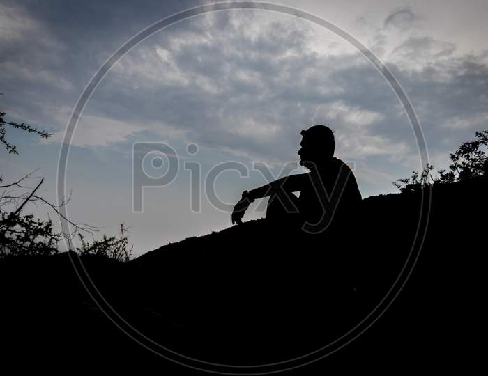 Man Sitting Shadow With Blue Sky Background Showing The State Of Loneliness