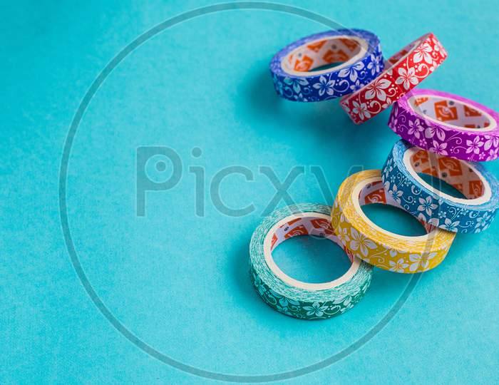 Gift Wrapping Colorful Floral Printed Tapes On Cyan Background