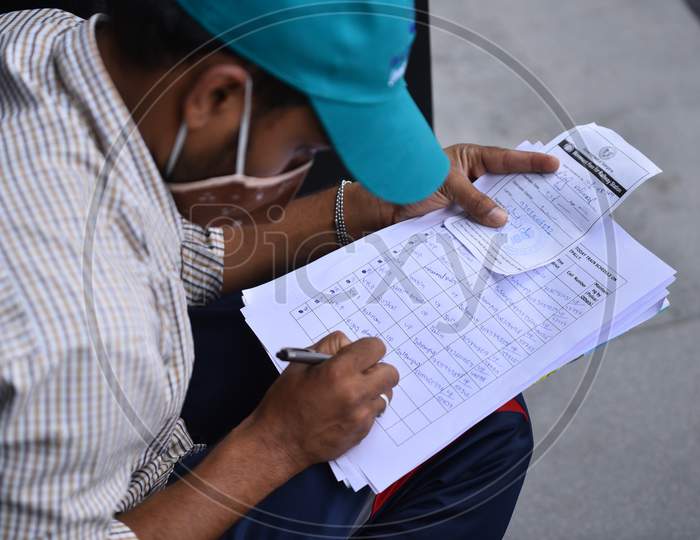 A Cyberabad Police volunteer registers Migrant workers details to issue them a pass to travel free to their native states on Shramik Special Trains, Hyderabad,May 19,2020.