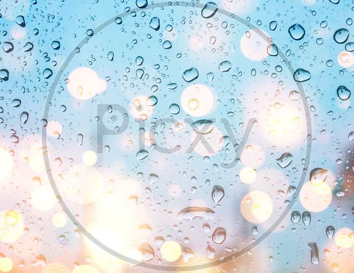 water drops on glass window with bokeh lights