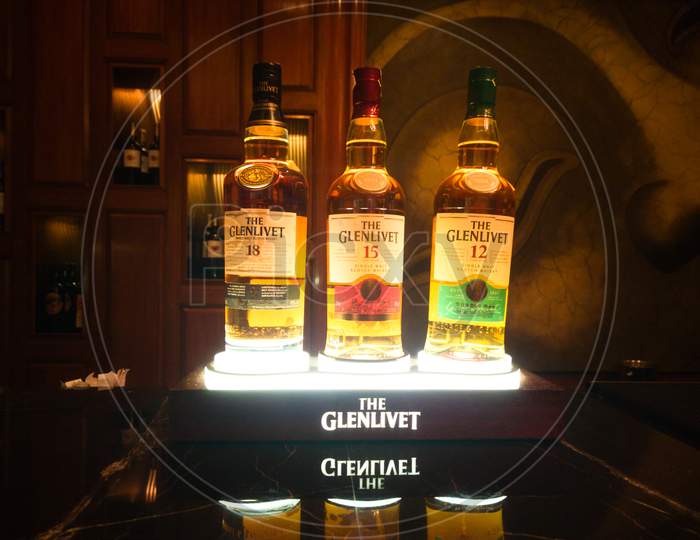 Photograph Of Glenlivet Bottles Arranged On A Beautifully Lit Stand