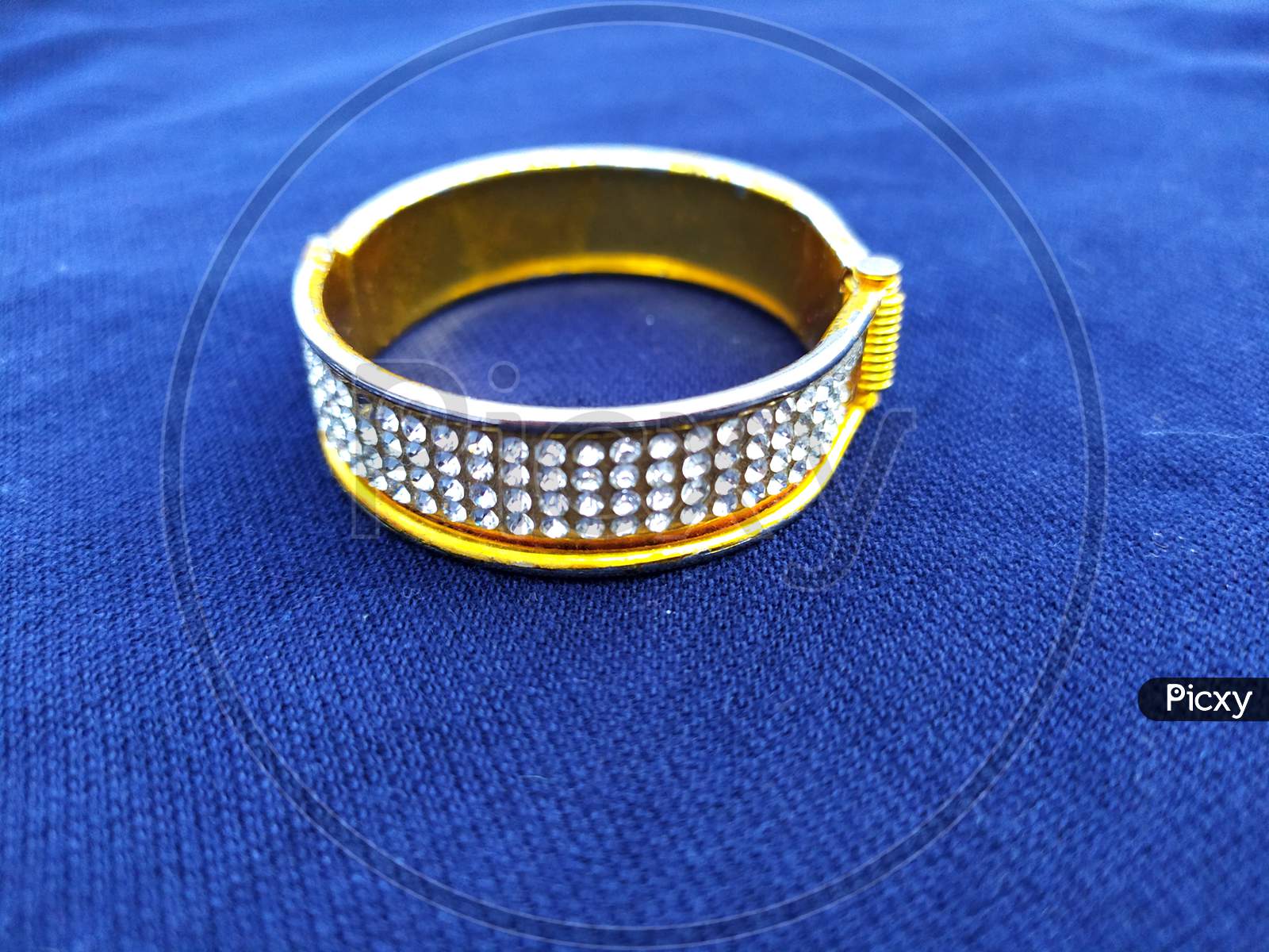 golden diamond bangles isolated on blue background