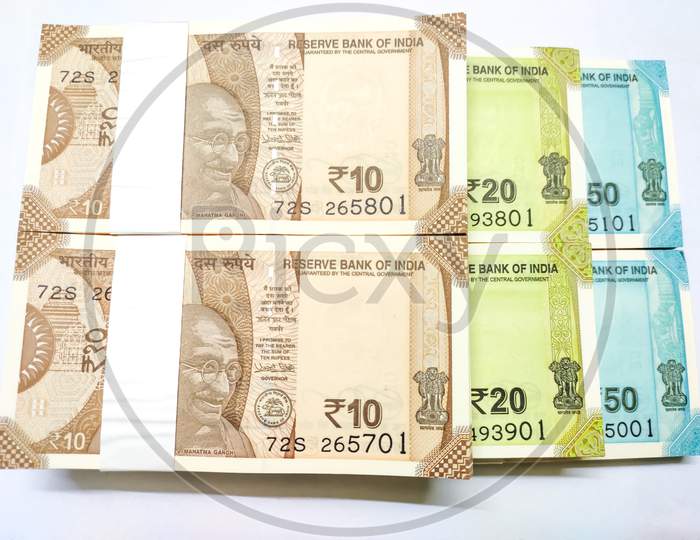 Close up view of Ten, Twenty & Fifty Indian Rupee banknotes bundle isolated on white background