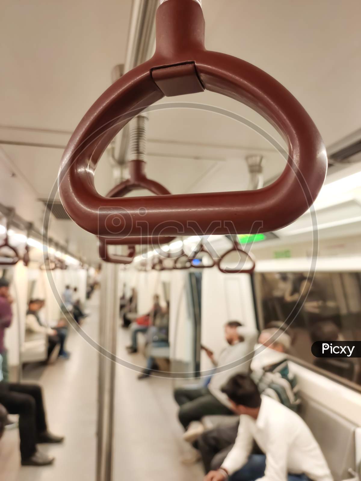 Close up of empty handrails in a Delhi metro train, Handle hand straps in public transportation for passenger safety. Brown hanging handhold for standing passengers in a modern metro train.