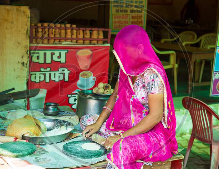Jaipur, Rajasthan, India - June 18Th, 2019: Indian Woman In Veil Flattening Dough Holds Rolling Pin, Preparation Of Chapati Brown Bread, Self-Employed Cook And Women Empowerment Concept