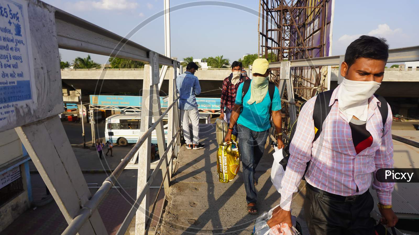Indian migrant workers affected due to COVID 19 Corona Virus nationwide lockdown. Migrant workers returning back home via special trains or bus. Indian Police on duty. Standing in queue on railway station with Social distancing and wearing medical mask.