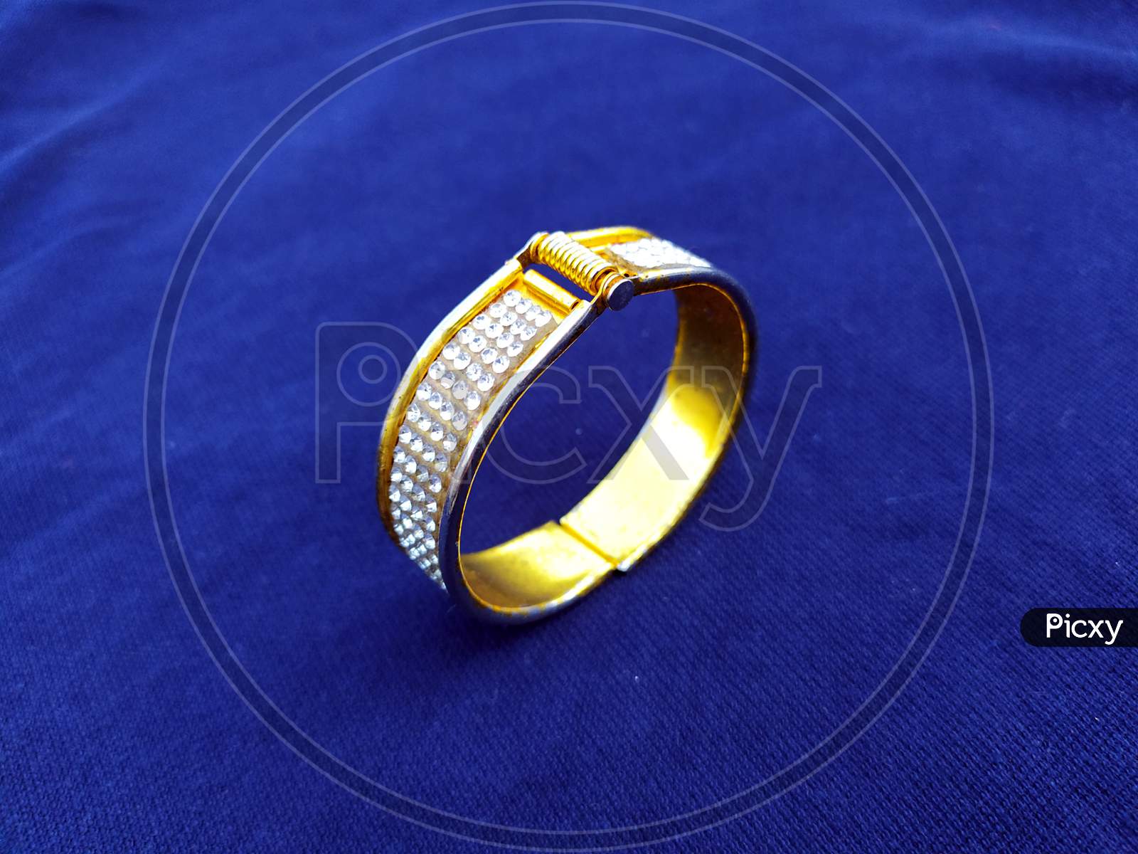 golden diamond bangles isolated on blue background