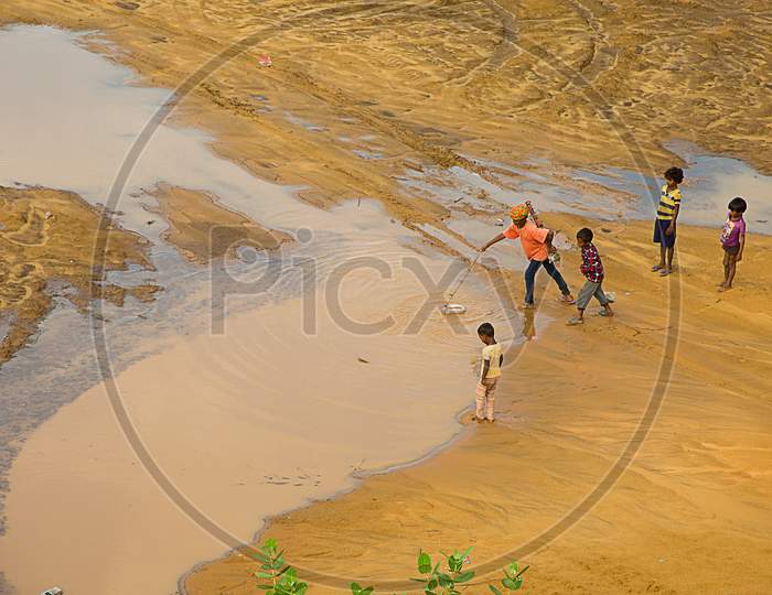 Jaisalmer, Rajasthan, India - June 18Th, 2019: Kids Searching Filling Leftover Water From Desert, Water Shortages, Concept Drought And Crisis Environment.