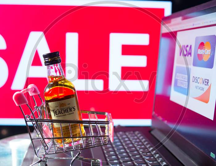 A bottle of whiskey in a trolley in front of a red sale board