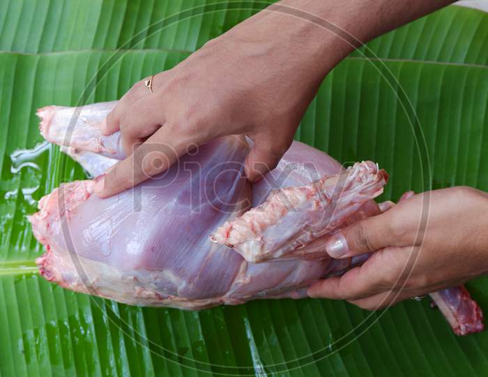 fresh full chicken meat cleaning by lady hand  , banana leaf ,ready to cook,raw chicken
