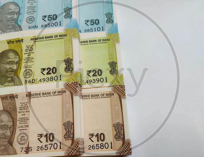 Close up view of Ten, Twenty & Fifty Indian Rupee banknotes bundle isolated on white background