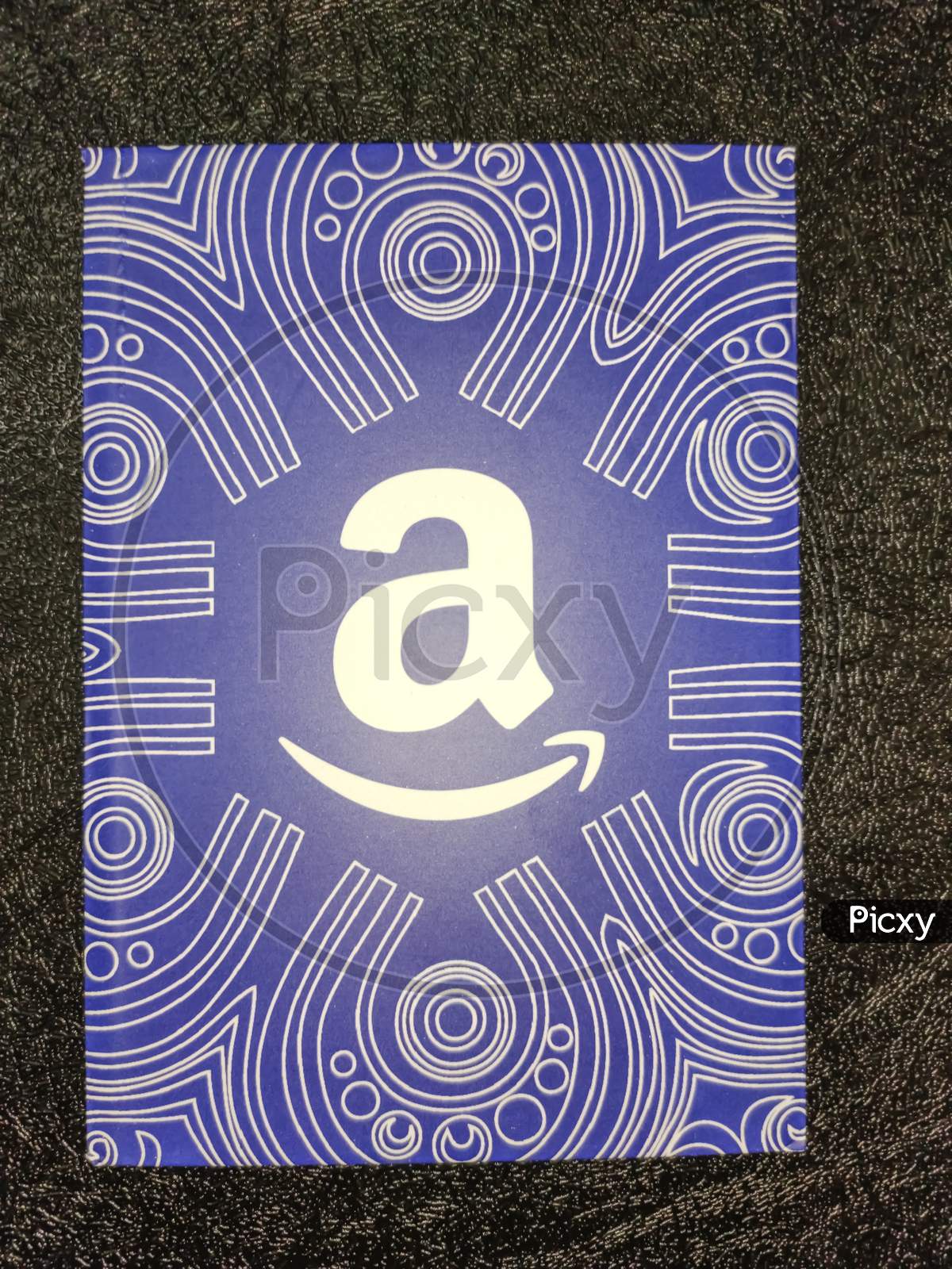 Amazon gift card with black texture background, which allows the recipient to purchase items from the Amazon.com website