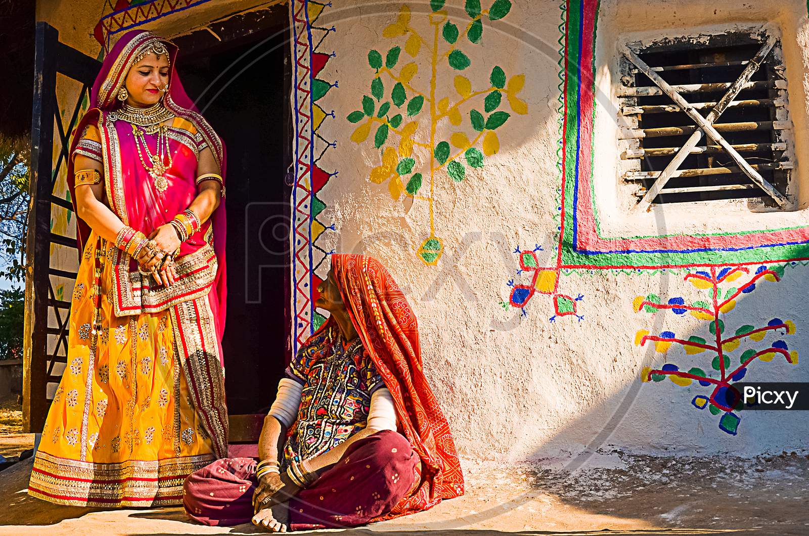 Jaisalmer, Rajasthan, India - April 18Th, 2018: Indian Village Women Outside Their House Wearing Ethnic Traditional Outfits, Village Life Concept