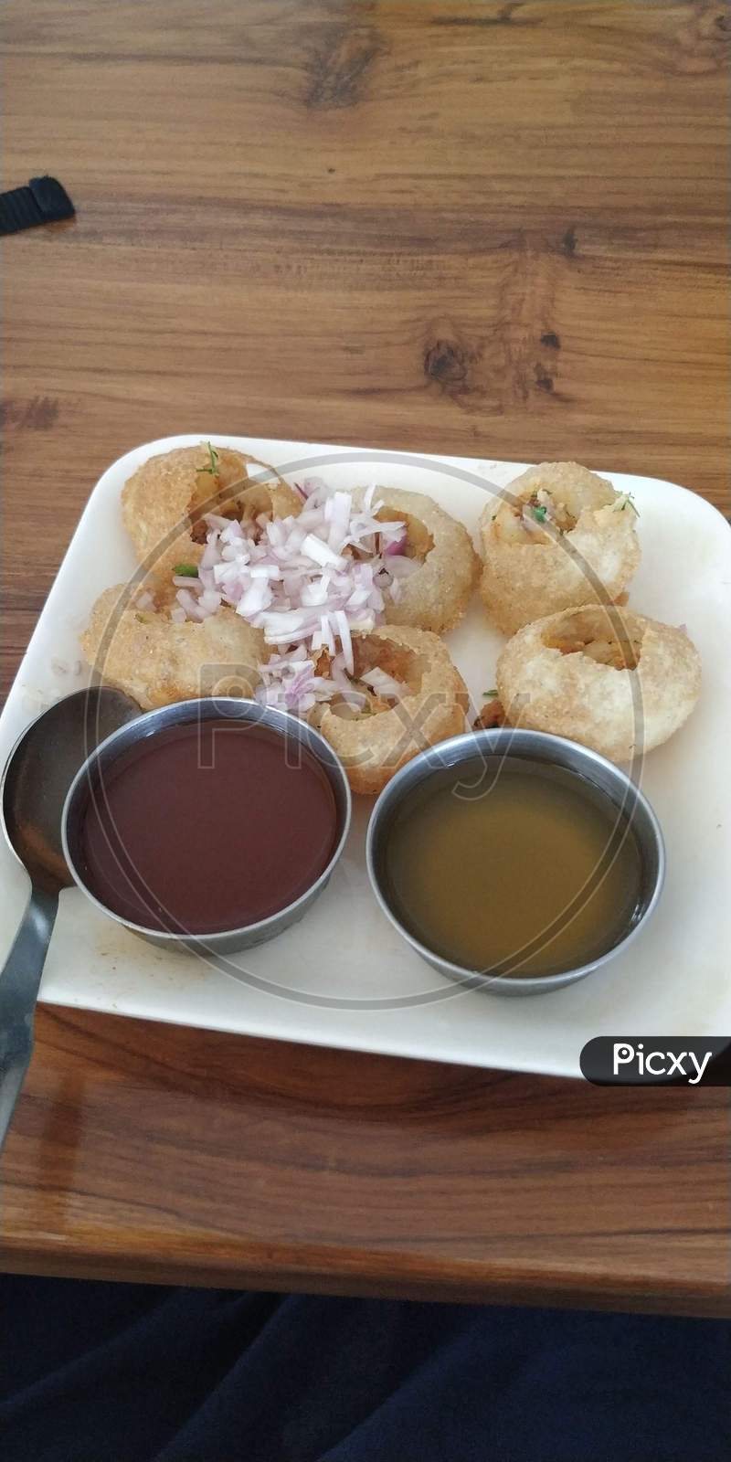 Famous Indian Street Food Called Pani Puri Or Golgappe With Sweet And Spicy Chutney With Onion And Aloo Or Potato Masala On White Plate