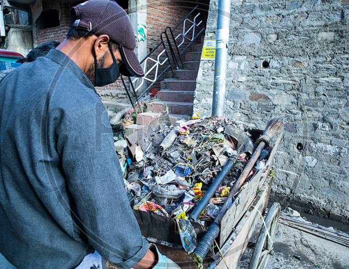 Shimla, Himachal Pradesh, India - July 20Th, 2019: Indian Asian Garbage Man Collecting Garbage In The Garbage Cart. Concept About Environmental Conservation And Ocean Pollution Problems