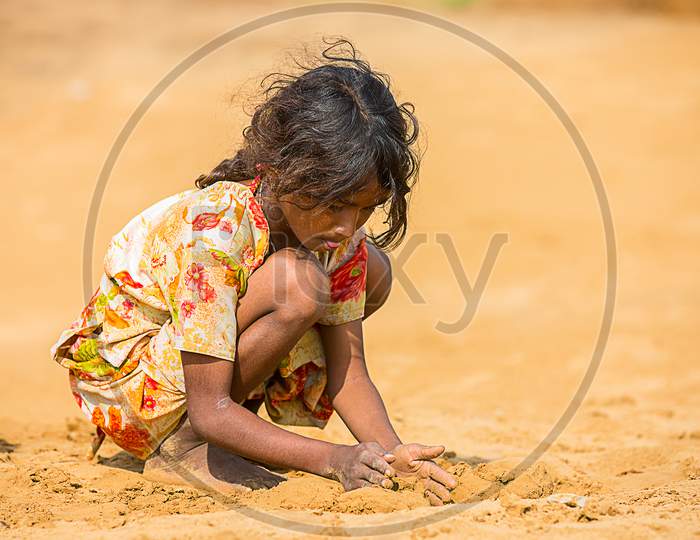 Jodhpur, Rajasthan, India - June 18Th, 2019: Poor Rural Girl Playing With Sand In Hot Summer, Poverty Unprivileged Indian Children.