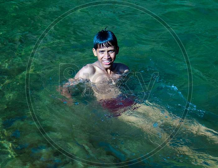 Nerwa Village, Himachal Pradesh, India - July 20Th, 2019: Young Indian Boy Swimming In The Fresh River Water. Summer Vacation Concept