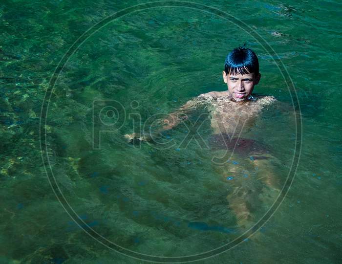 Nerwa Village, Himachal Pradesh, India - July 20Th, 2019: Young Indian Boy Swimming In The Fresh River Water. Summer Vacation Concept