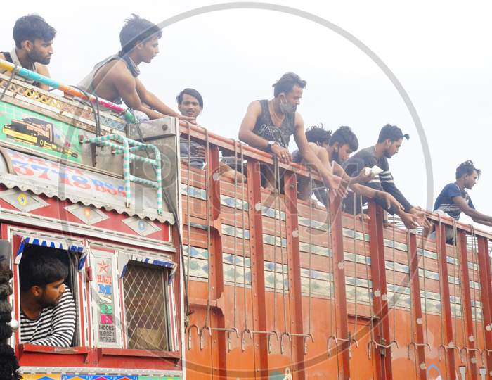 Migrant Labours travelling to Uttar Pradesh and Bihar by road on a truck halting for getting food packets and drinking water at Jabalpur