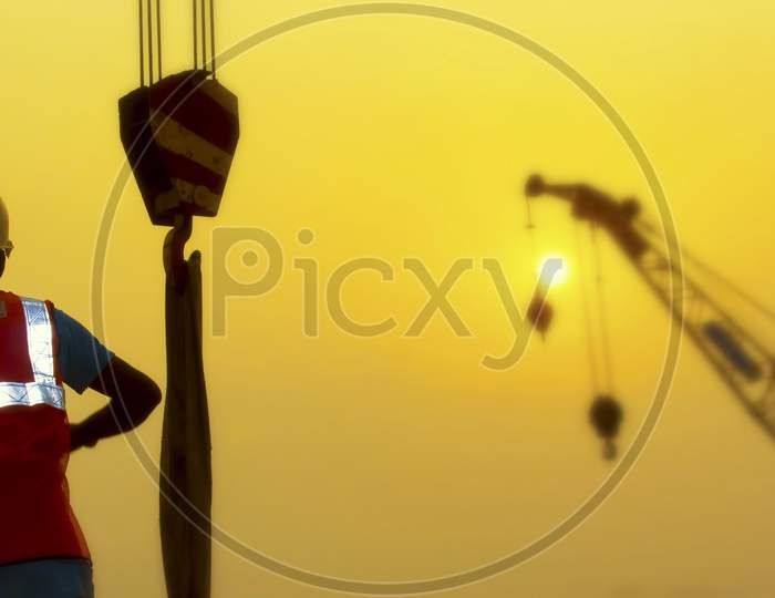 Dhaka,Bangladesh-January 10,2020 : Portrait Of Architect Silhouette Wear A Helmet At Construction Site With Crane Background And Sunset.