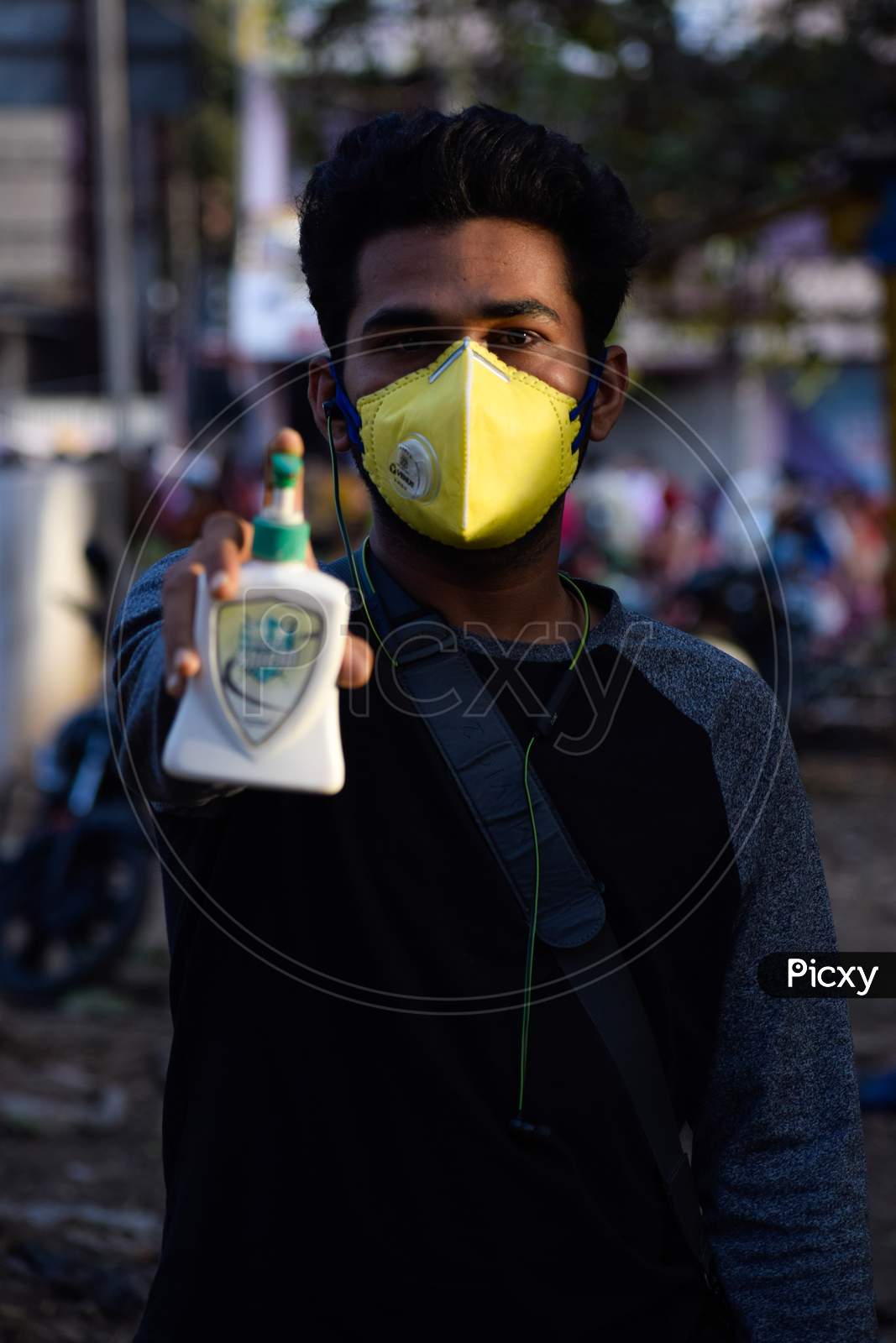 Bharuch, Gujarat/India - March 20, 2020: A men wearing CORONA VIRUS MEDICAL MASK for the prevention of COVID-19 CORONA VIRUS while showing sanitizer in his hand. Selective focus.