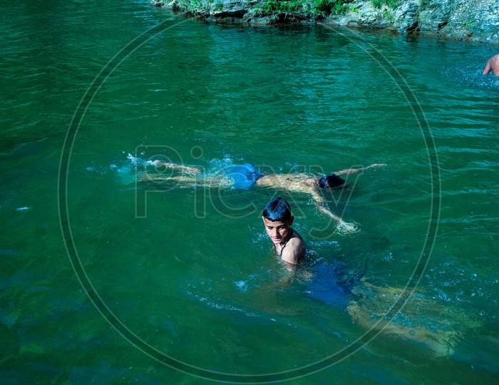 Nerwa Village, Himachal Pradesh, India - July 20Th, 2019: Young Indian Boys Having Fun Swimming In The Fresh River Water. Summer Vacation Concept