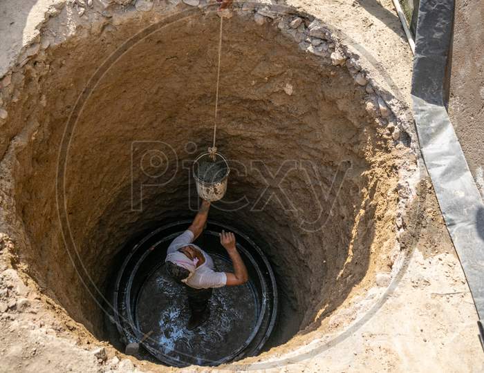 a man uses concrete to construct a septic tank