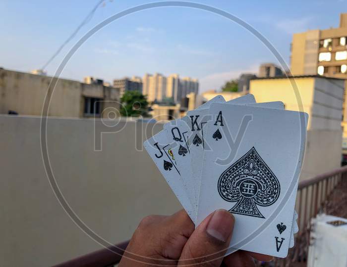 young guy holding four cards in one hand
