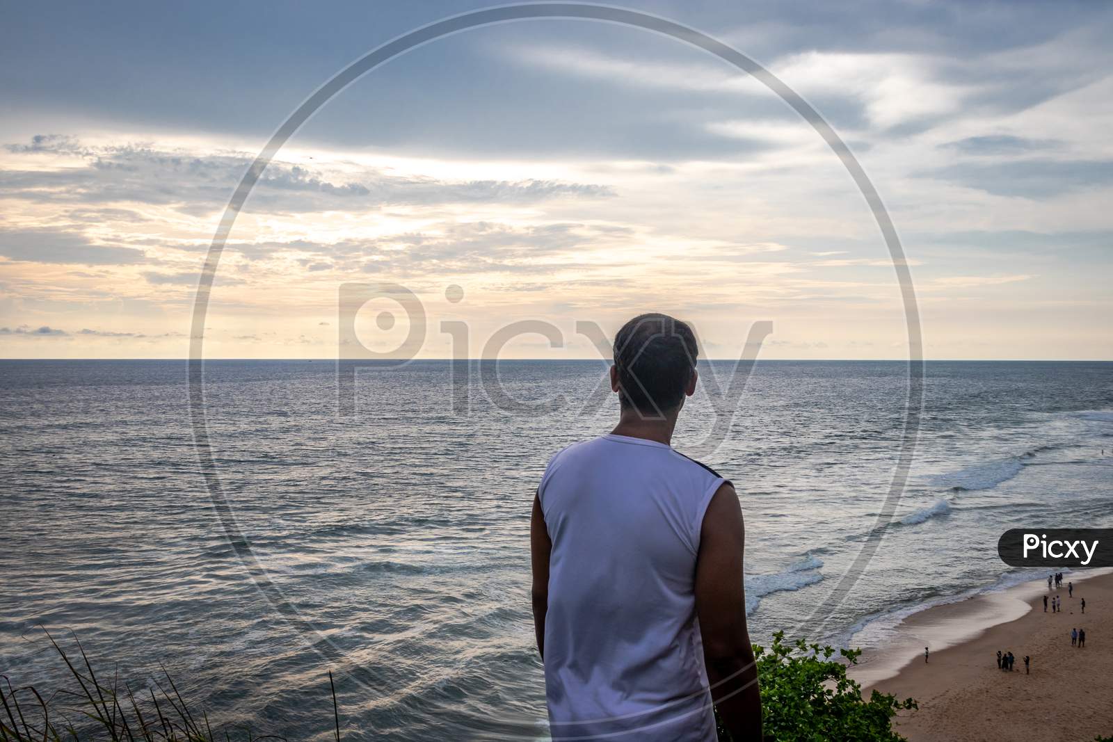 Isolated Man Watching Sunset Over Sea Horizon