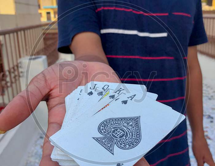 young Asian guy holding deck of cards