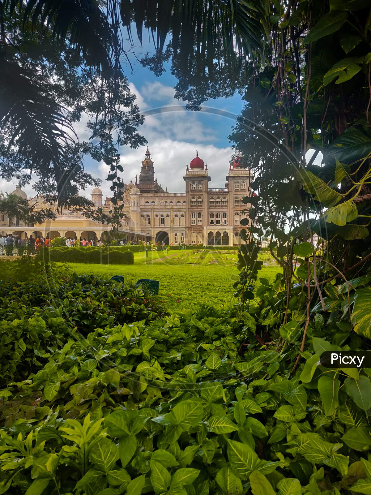 Side View Of Mysore Palace From Between Trees And Bushes In Mysore, India.